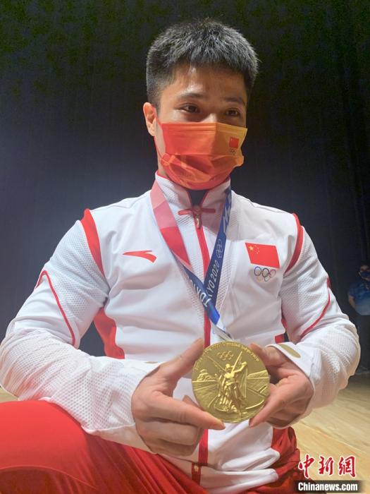 李发彬向记者展示金牌，分享夺冠喜悦。